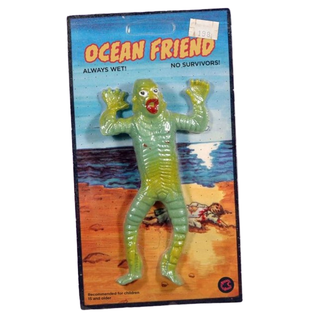 an old fashioned toy shaped like a humanoid fish monster, the packaging reads 'Ocean Man! always wet! no survivors!'